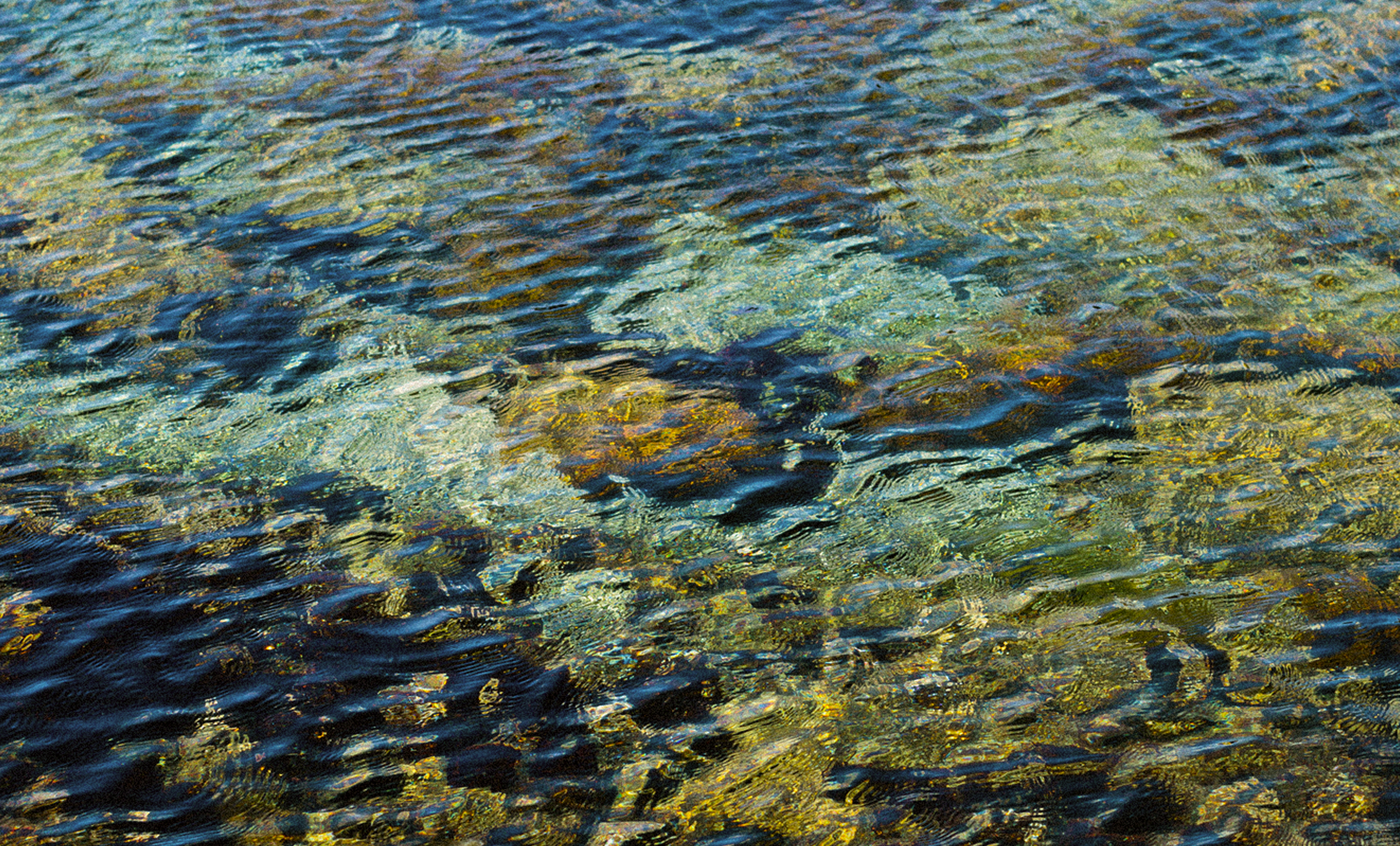 Light ripples across shallow water, reflecting Glow's layered deposit and reward flows.