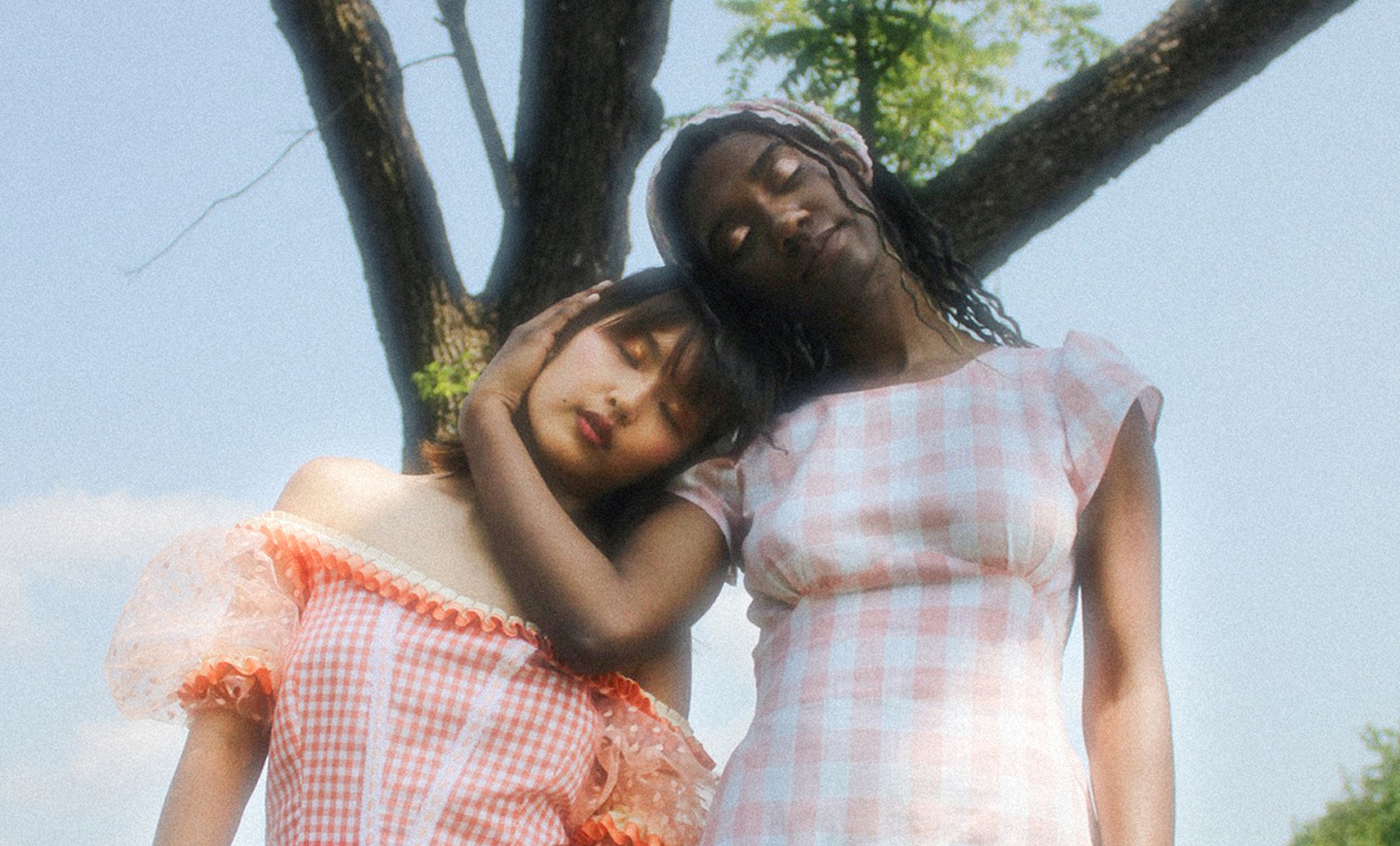 Girl leaning against a tree